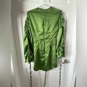 Green satin dress. Small zipper with frayed fabric on backside of the dress.